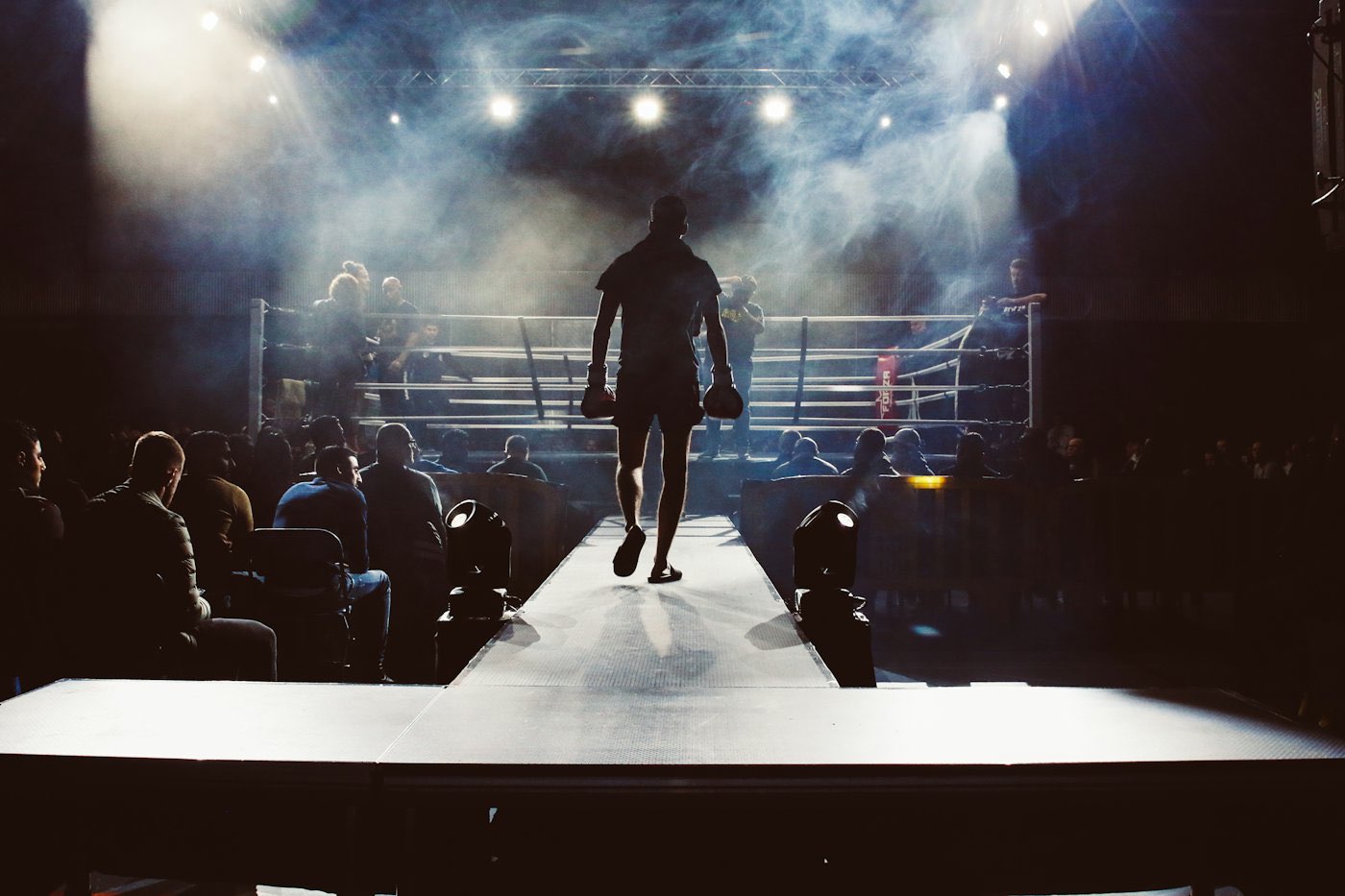 A boxer walking out to the ring under spotlights